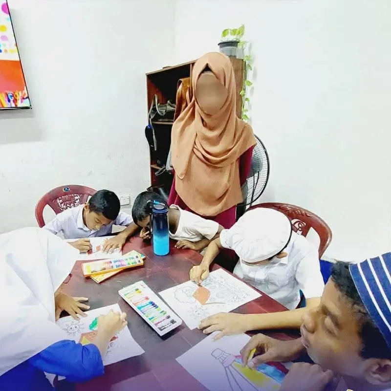 Children drawing together with their teacher